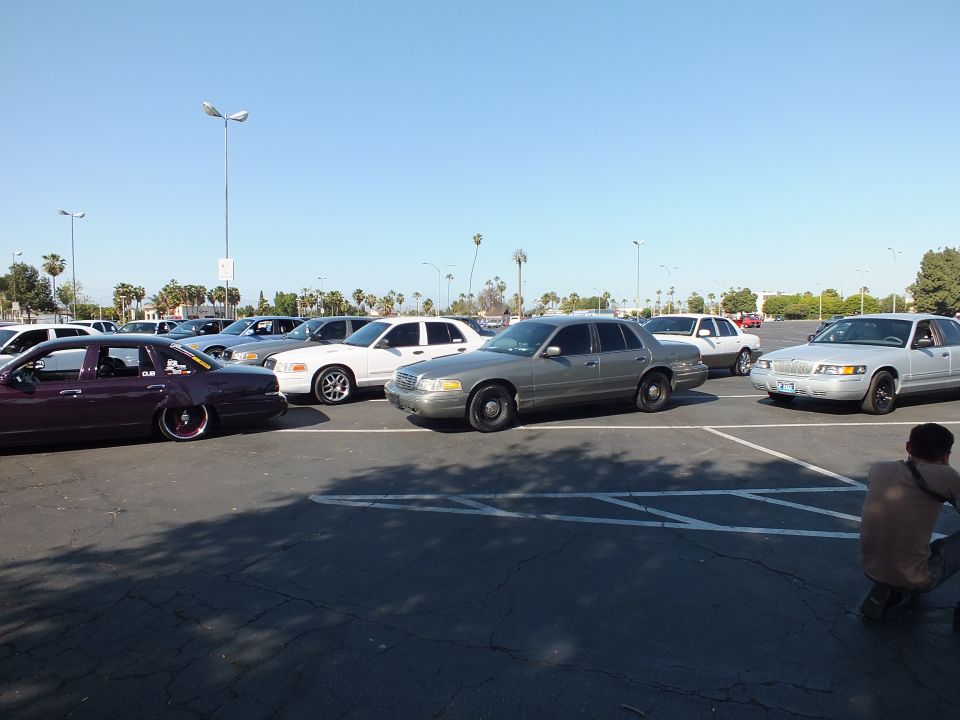 Maroon lowered sedan, silver and white sedans in a parking lot