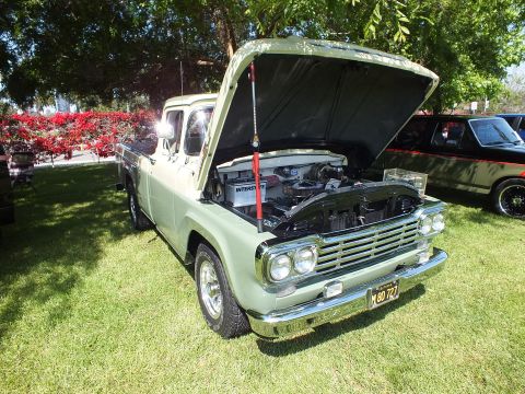 2003 Ford Crown Victoria - light-green classic Ford pickup with quad headlights and open hood displays its engine on a grassy show field.