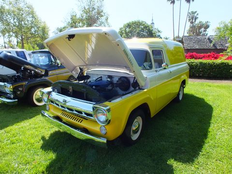 2003 Ford Crown Victoria - two-tone yellow and white vintage Ford panel truck with its hood raised, parked on a lawn beside another classic vehicle.