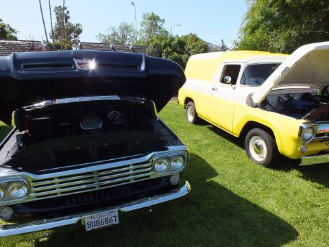 2003 Ford Crown Victoria - Close front view of a black show vehicle with its hood up and California plate, next to a yellow-and-white panel truck on grass.