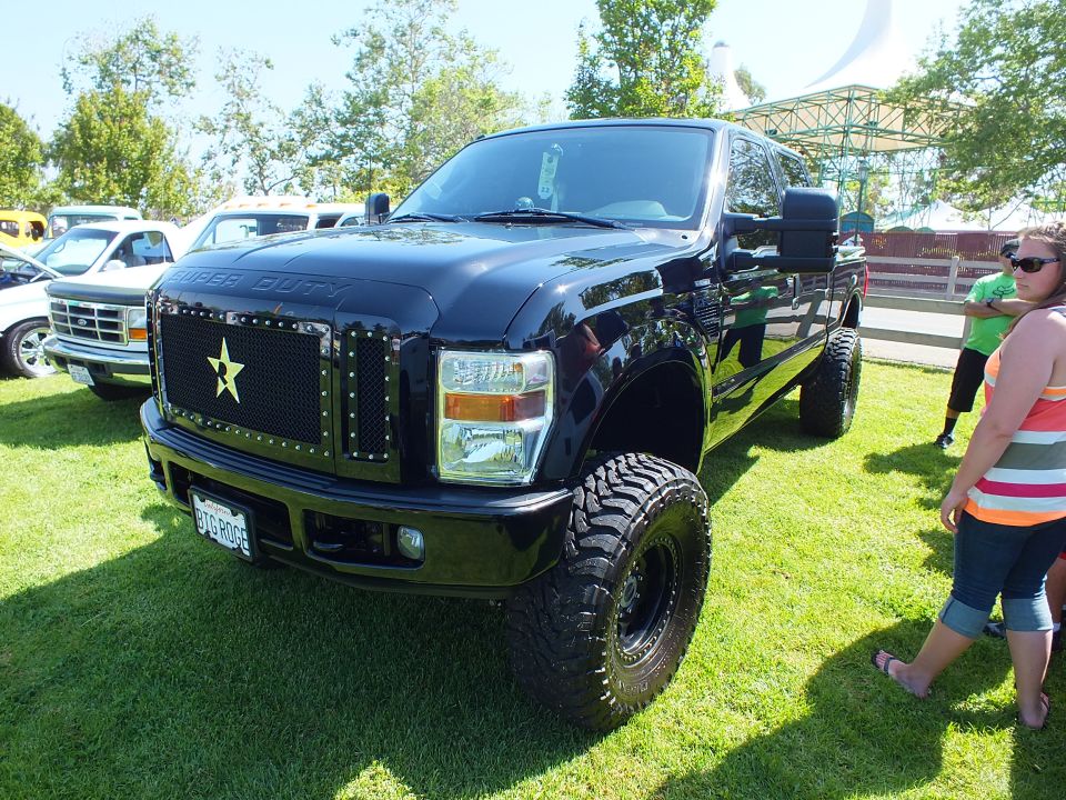 Black lifted Ford Super Duty truck with star grille on grass