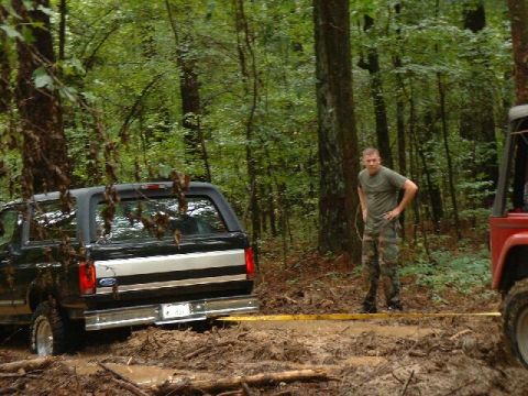 1995 Ford Bronco - A man watches as a Ford Bronco gets stuck in the mud during an off-road excursion.
