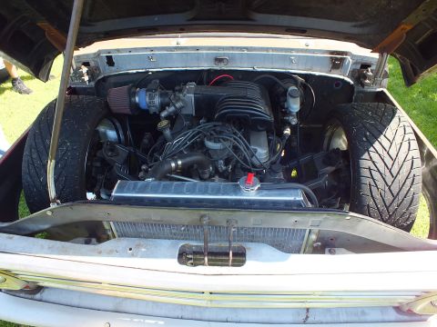 2003 Ford Crown Victoria - Open engine bay of a customized vintage pickup showing a swapped fuel-injected V8 with a red cone intake, coil-over plug wires and a polish…