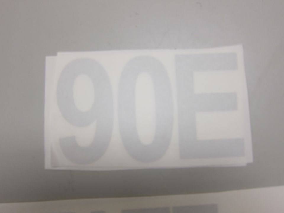 Decal with large gray numbers "90" and letter "E" on a white background