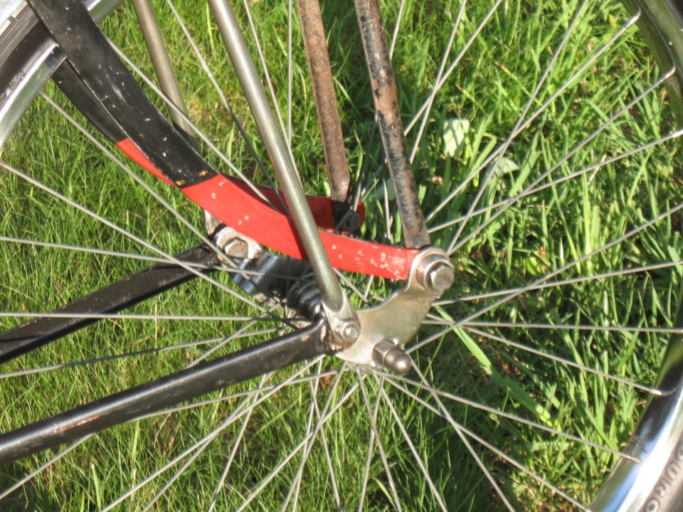 Bicycle front fork with red and black paint, chrome rim, and spokes
