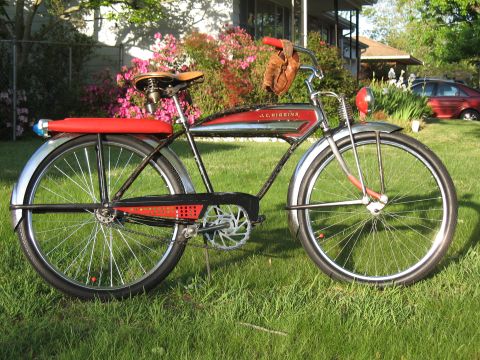 1994 Ford Bronco - A vintage J.C. Higgins bicycle sits on a grassy lawn with flowering bushes in the background.