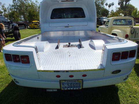 2003 Ford Crown Victoria - light blue custom dually flatbed truck viewed from the rear, with a diamond-plate deck, Ford tailgate, and a California license plate.
