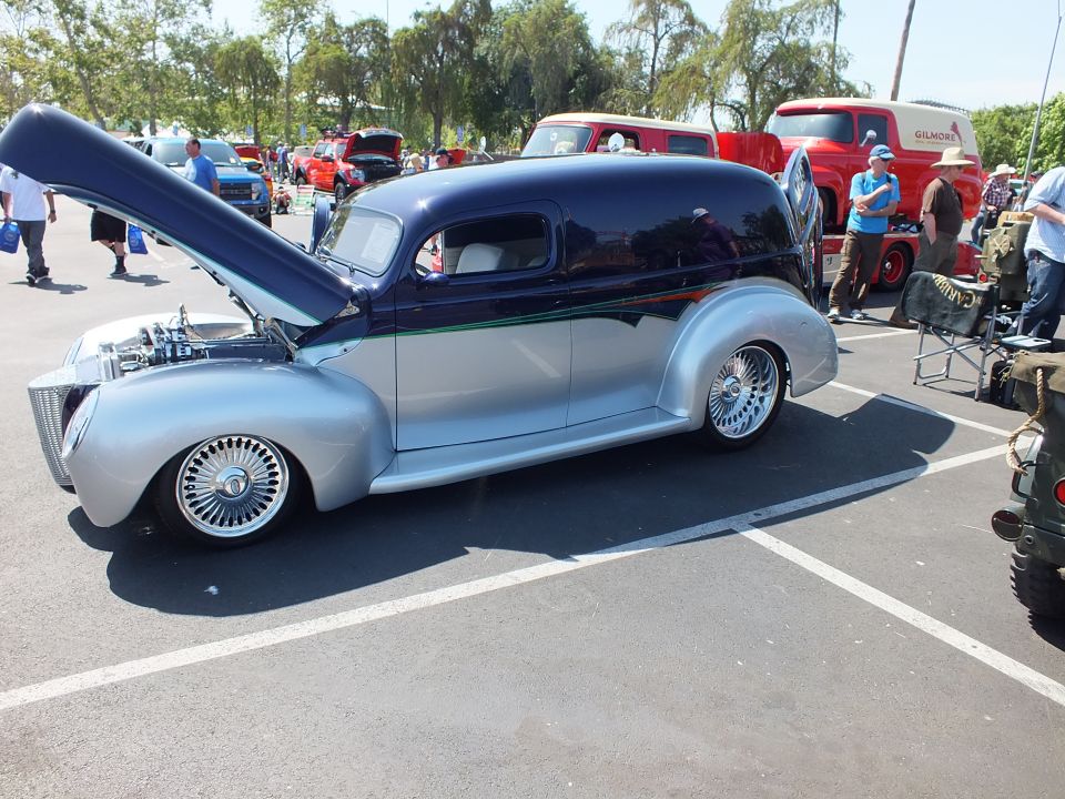 Side view of blue and silver custom sedan delivery hot rod with open hood and wire wheels