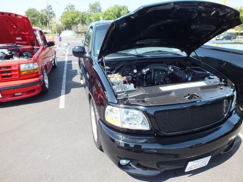 2003 Ford Crown Victoria - Front three-quarter view of a black Ford pickup with hood raised, billet grille and a California license plate.