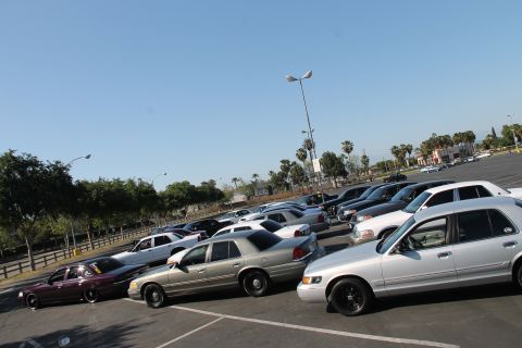 1992 Ford Crown Victoria - Several Ford Crown Victorias are parked in a lot under a clear blue sky.