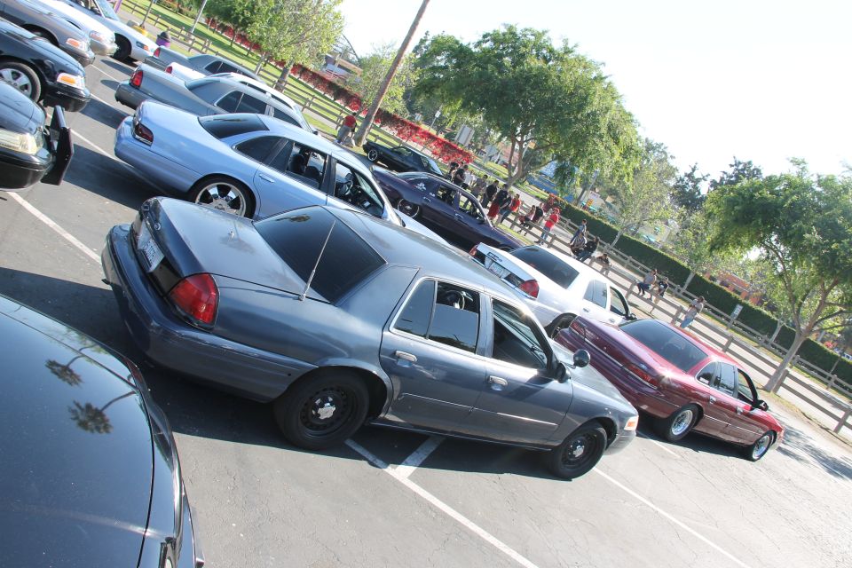 Gray Ford Crown Victoria police car parked in lot with other vehicles