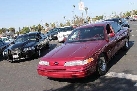 1992 Ford Crown Victoria - A red 1992 Ford Crown Victoria is parked in a lot with other vehicles visible.