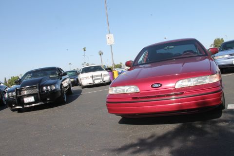 1992 Ford Crown Victoria - A red 1992 Ford Crown Victoria is parked in a lot with other vehicles.