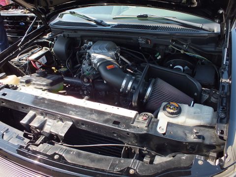 2003 Ford Crown Victoria - open engine bay featuring a supercharged Ford V8 with a black K&N conical air-intake filter and coolant reservoir.