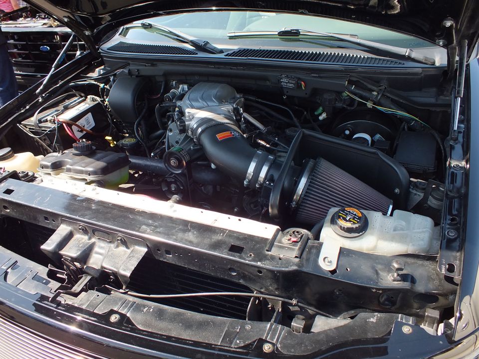 Engine bay showing a supercharger and a black K&N conical air intake filter