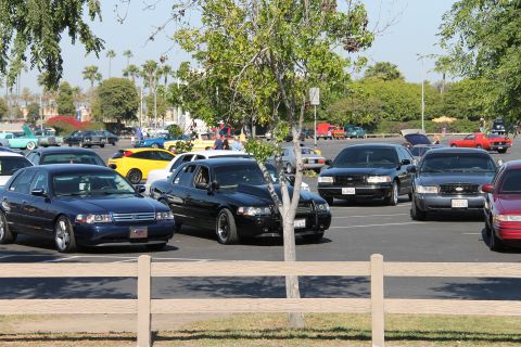 1992 Ford Crown Victoria - A dark blue 1992 Ford Crown Victoria is seen from a 3q front angle at a car show, with multiple other vehicles present in the background.