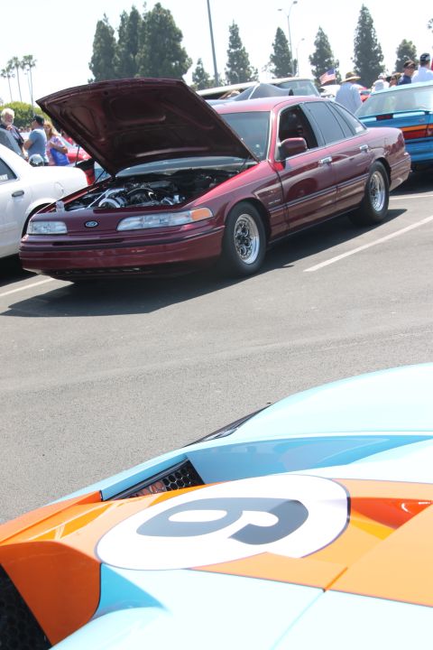 1992 Ford Crown Victoria - A maroon 1992 Ford Crown Victoria is displayed with its hood open at a car show, with another car visible in the foreground.