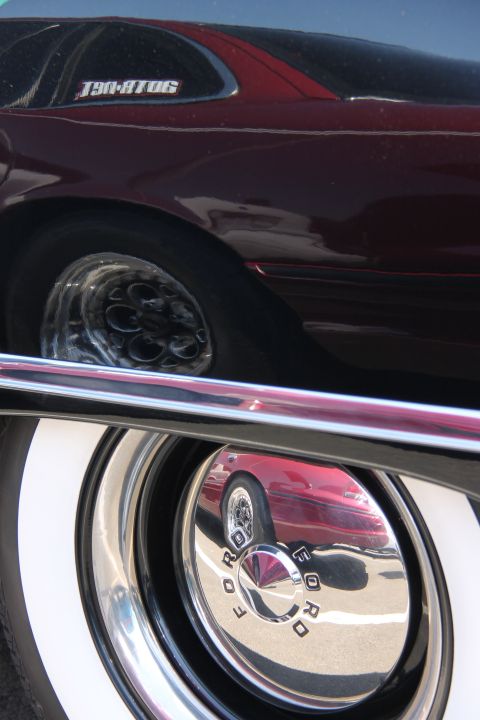 1992 Ford Crown Victoria - A close-up of a 1992 Ford Crown Victoria's side profile, showing its whitewall tires and a reflection in the hubcap.