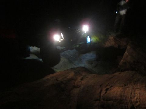 1994 Ford Bronco - Two off-road vehicles navigate a rocky path at night, illuminated by their powerful headlights.