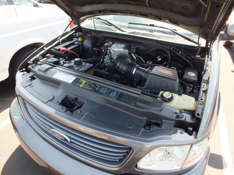 2003 Ford Crown Victoria - Close-up of a Ford pickup engine bay showing a supercharged V8 with the hood raised.