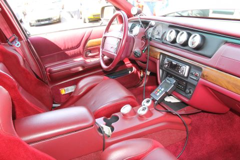 1992 Ford Crown Victoria - The interior of this car features red upholstery and custom gauges on the dashboard.