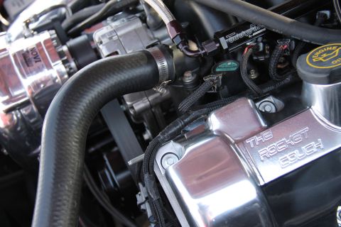 1992 Ford Crown Victoria - Close-up of a custom engine bay chrome valve covers engraved with "THE ROCKET COUCH" and a Novi supercharger.