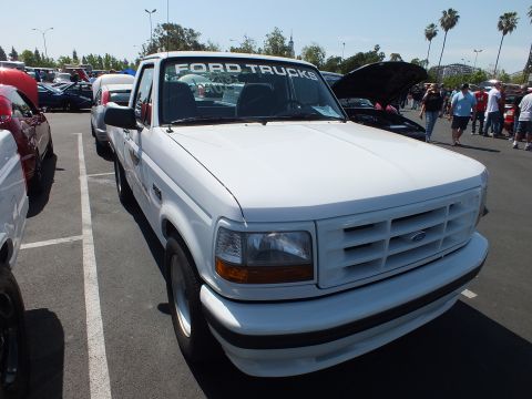 2003 Ford Crown Victoria - Front three-quarter view of a white Ford F-150 Lightning pickup with a Ford Trucks windshield banner.