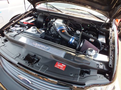 2003 Ford Crown Victoria - Detailed engine bay of a black Ford SVT Lightning showing the supercharger and aftermarket intake.