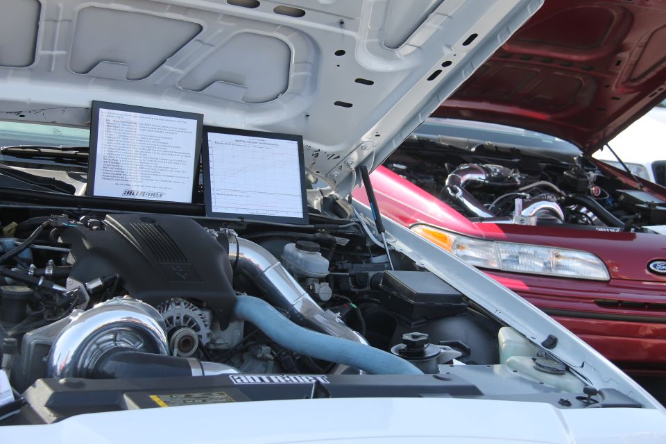 1992 Ford Crown Victoria engine bay with custom turbo setup, another red Ford Crown Victoria behind it