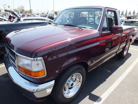 2003 Ford Crown Victoria - Front three-quarter view of a maroon 1990s Ford F-150 single-cab pickup at an outdoor car show.