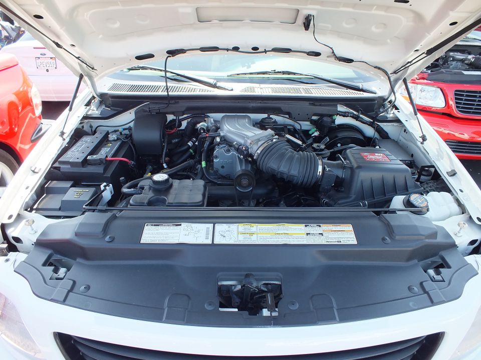 Engine bay of a white Ford Lightning showing supercharged V8
