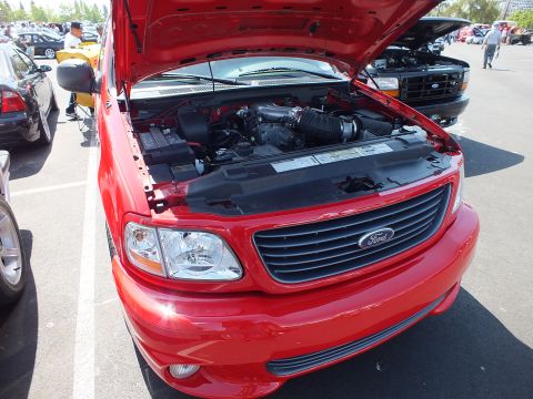 2003 Ford Crown Victoria - Front three-quarter view of a red Ford F-150 Lightning pickup displayed with its hood raised.