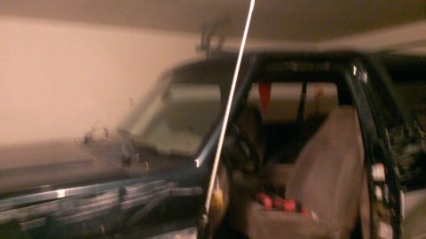 1994 Ford Bronco - Interior of a dark SUV, with a white pole obscuring part of the view.