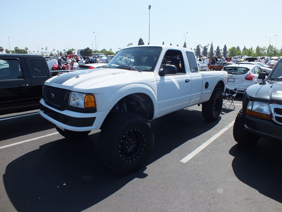 White lifted Ford Ranger extended cab prerunner-style pickup at outdoor car show
