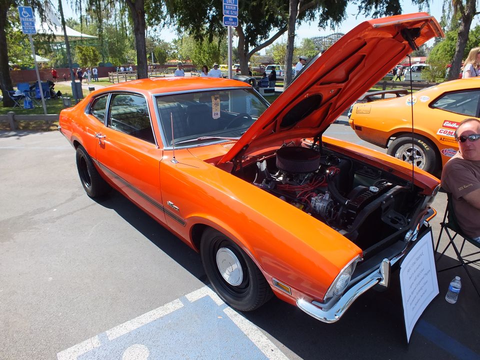 Orange Ford Maverick Grabber coupe with chromed engine and open hood
