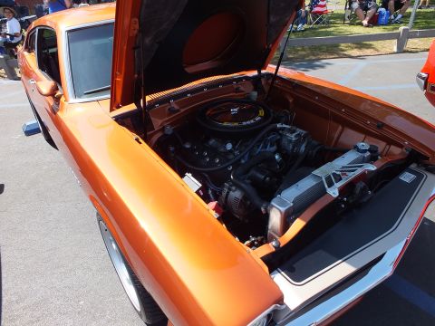 2003 Ford Crown Victoria - engine bay of an orange car viewed through its open hood, showing a chrome air-cleaner lid and detailed inner fenders.