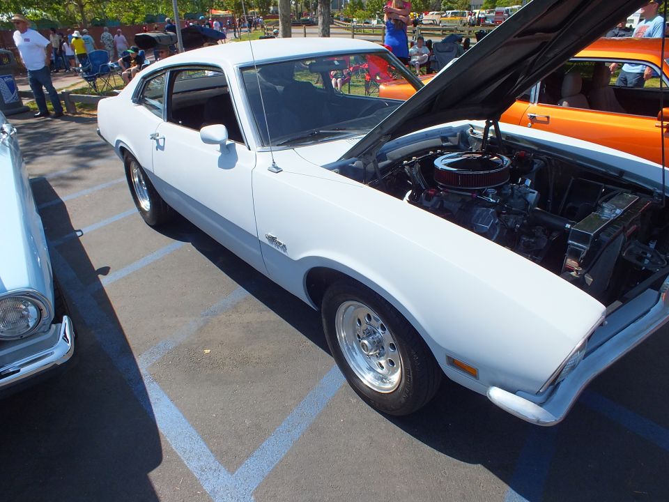 White Ford Maverick fastback with open hood at car show