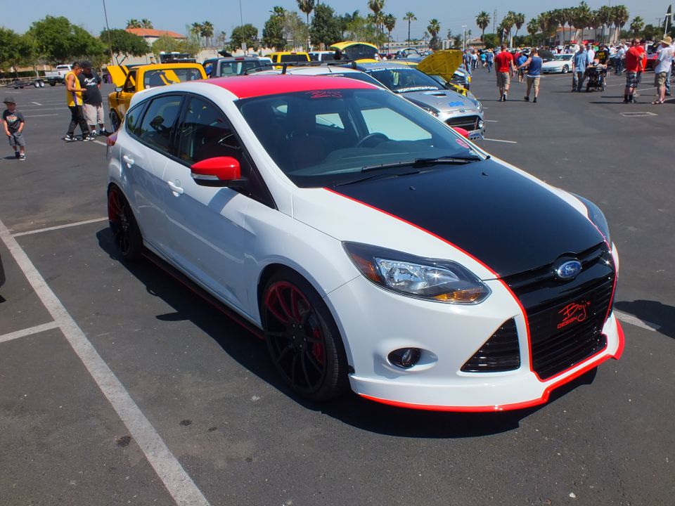 White Ford Focus hatchback with red and black hood graphics at a car show