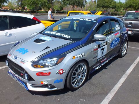 2003 Ford Crown Victoria - silver Ford Focus ST hatchback wearing number 7 rally livery with Ford, Hankook, and Rally Innovations sponsor decals at a show.