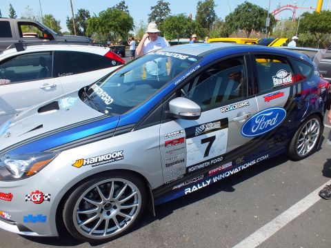 2003 Ford Crown Victoria - Side view of a blue-and-silver Ford Focus race car displaying number 7, a large Ford oval, and Hankook and Rally Innovations decals.