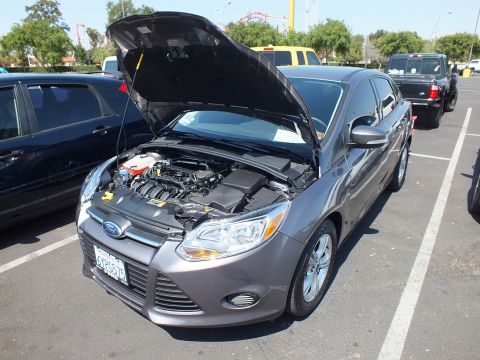 2003 Ford Crown Victoria - Front three-quarter view of a gray Ford Focus sedan with the hood raised showing the engine, parked at an outdoor car meet.