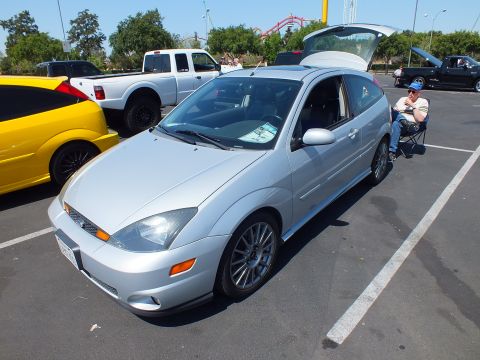 2003 Ford Crown Victoria - silver Ford Focus hatchback with its rear hatch open and gray alloy wheels, parked in a show lot.