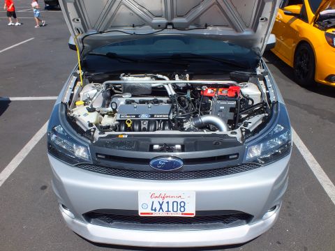 2003 Ford Crown Victoria - Front view of a silver Ford Focus with hood raised, showing the engine bay above a California plate reading 4X108.