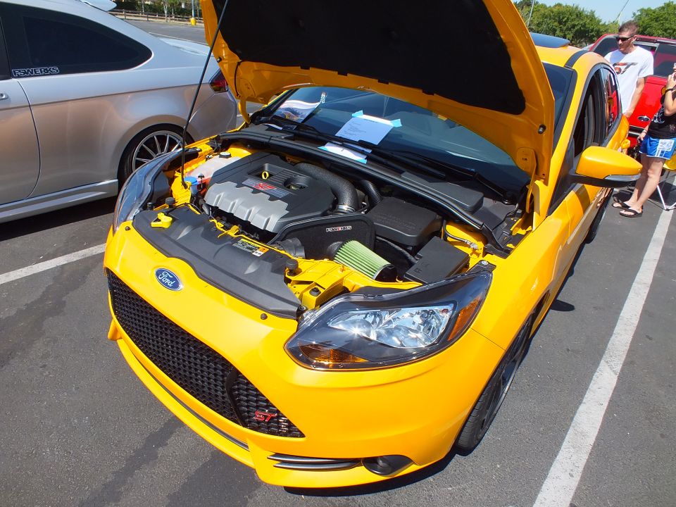 Front of yellow Ford Focus with hood open showing engine bay