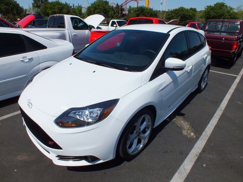 2003 Ford Crown Victoria - white Ford Focus ST hatchback with silver alloy wheels parked among other cars at an outdoor show.