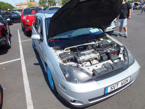 2003 Ford Crown Victoria - silver Ford Focus coupe with hood raised, blue caliper accents, and a front plate reading SVT WGN at a car show.