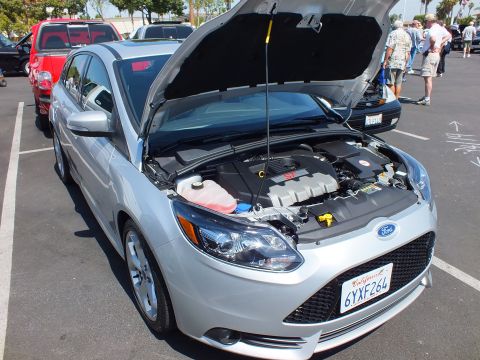 2003 Ford Crown Victoria - silver Ford Focus sedan with hood raised displays its engine bay in a parking lot full of show cars.