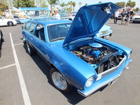 2003 Ford Crown Victoria - blue Ford Pinto wagon with chrome bumpers and hood raised displays its engine bay at an outdoor car show.