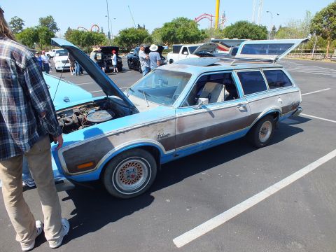 2003 Ford Crown Victoria - blue Ford Pinto wagon with faux wood side paneling has both its hood and rear hatch open at an outdoor car show.