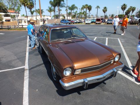 2003 Ford Crown Victoria - brown Ford Pinto station wagon is shown front three-quarter at an outdoor car show with palm trees in the background.